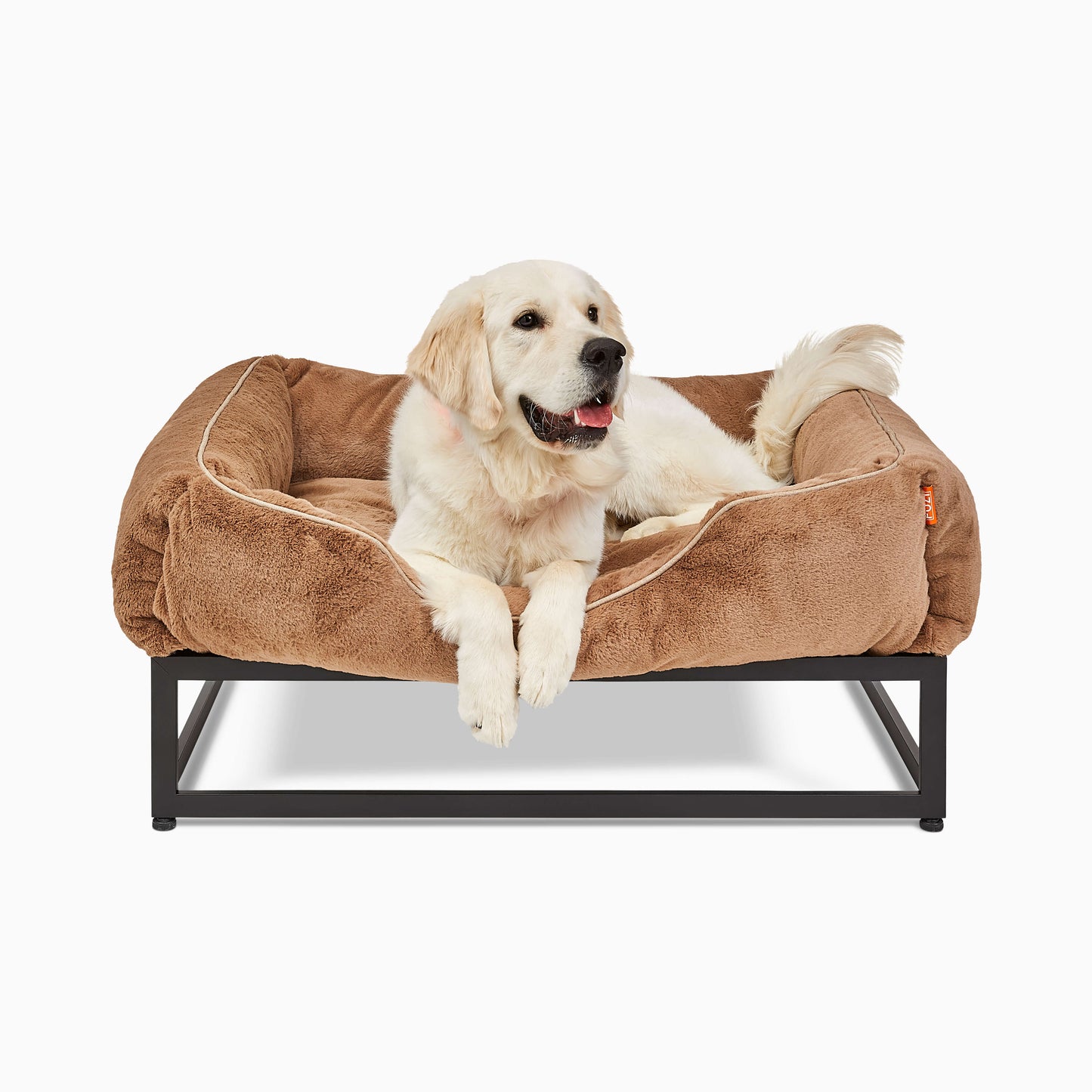 White large dog in a light brown faux fur elevated dog bed for large dogs by Fuzi, designed for enhanced airflow, support, and comfort, in light brown plush with a black metal base.