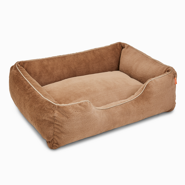 Sammy bolster dog bed in light brown faux fur by Fuzi, with a removable cover available in four beautiful colors and three sizes.