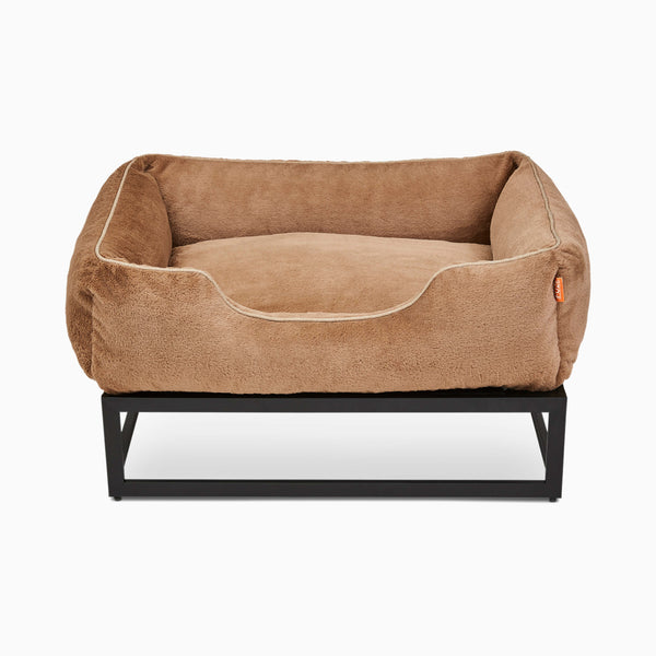 Light brown faux fur elevated dog bed by Fuzi, designed for enhanced airflow, support, and comfort, in light brown plush with a black metal base.