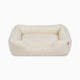 Sammy bolster dog bed in a medium white faux fur by Fuzi, with a removable cover available in four beautiful colors and three sizes.