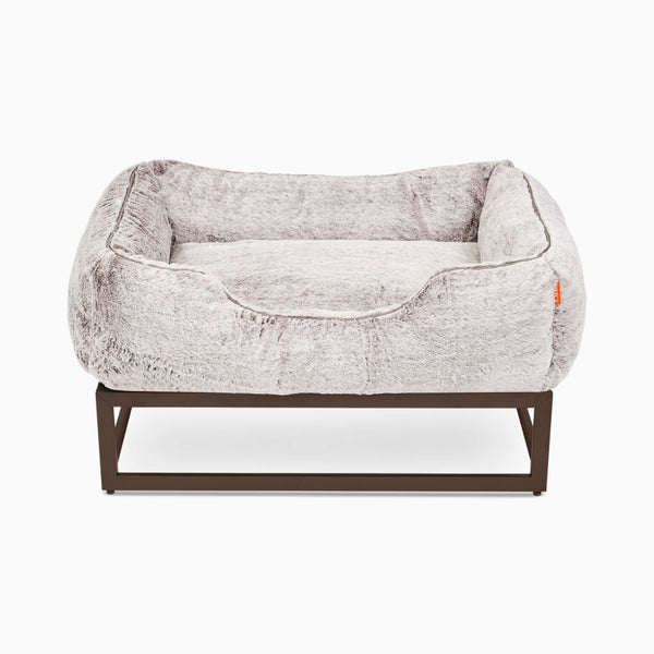 Light grey faux fur window seat dog beds by Fuzi, designed for enhanced airflow, support, and comfort, in light grey fur with a black metal base.