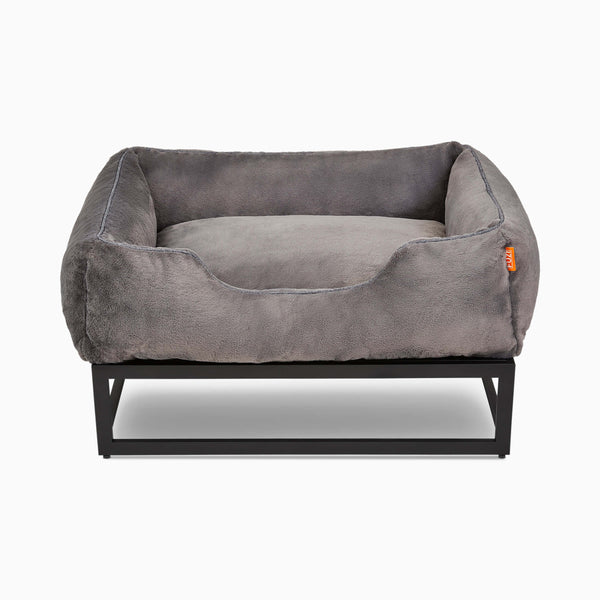 The Fuzi dog bed in dark grey faux fur elevated dog beds by Fuzi, designed for enhanced airflow, support, and comfort, in dark fur with a black metal base.