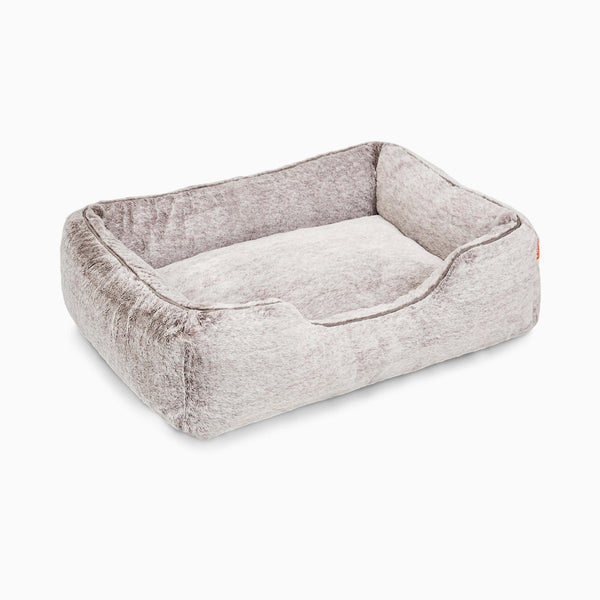 The Sammy bolster dog bed in medium light grey faux fur by Fuzi, with a removable cover available in four beautiful colors and three sizes.