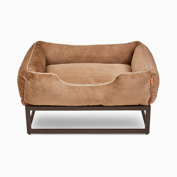 Medium light brown faux fur elevated dog bed by Fuzi, designed for enhanced airflow, support, and comfort, in light brown plush with a brown metal base.