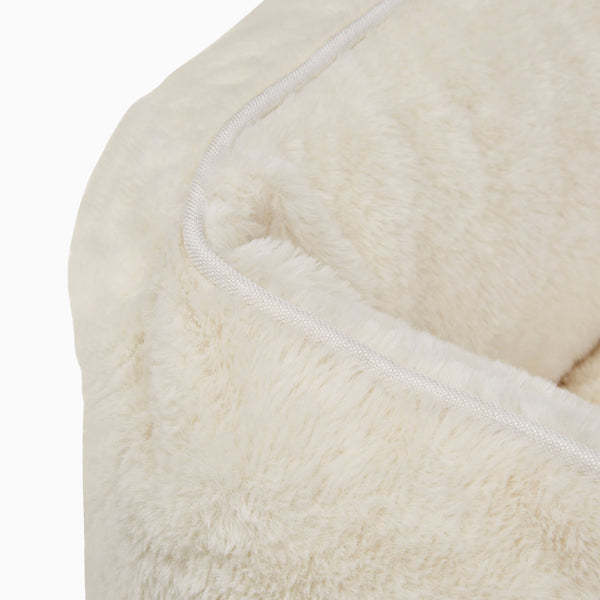 White swatch of Sammy bolster dog bed in a white faux fur by Fuzi, with a removable cover available in four beautiful colors and three sizes.